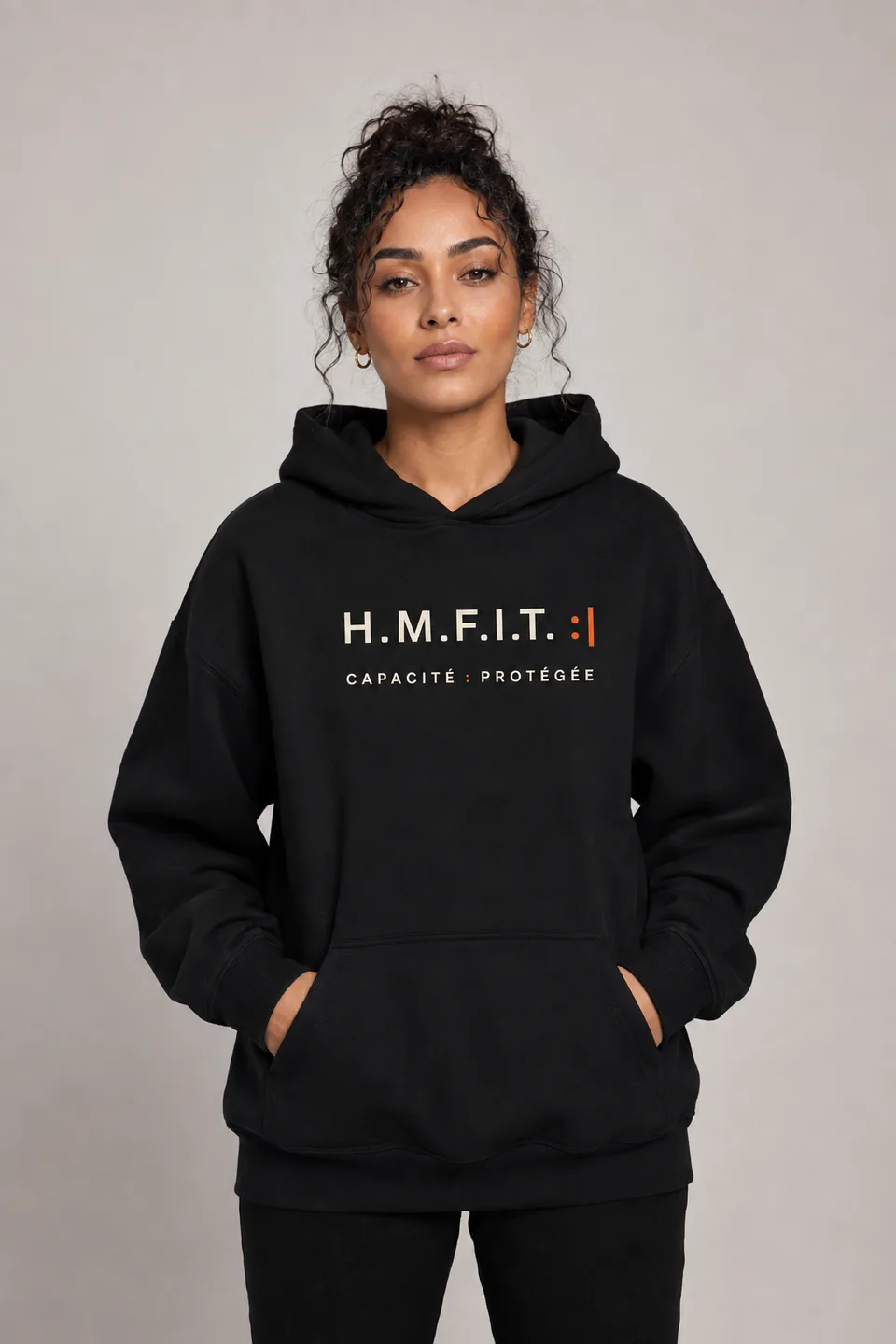 Le hoodie FAM/01 porté, vu de face — la ligne du vêtement se lit près du corps.