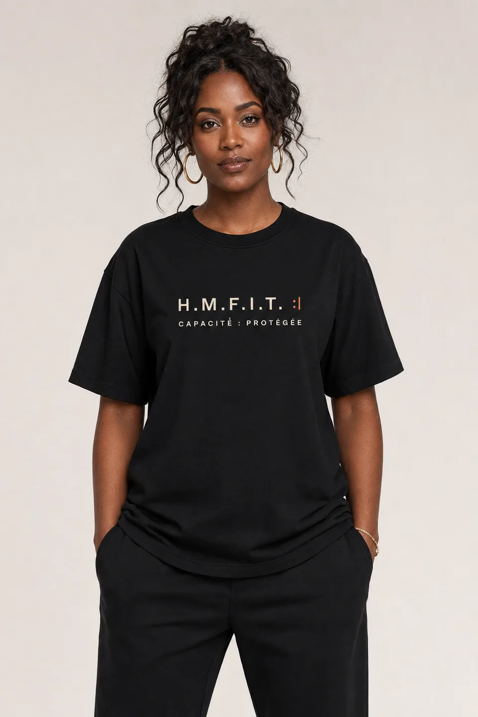 Le t-shirt FAM/01 porté, vu de face — imprimé sur la poitrine : « H.M.F.I.T. :| — CAPACITÉ : PROTÉGÉE ».